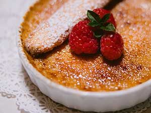 close up of creme brule top with raspberries